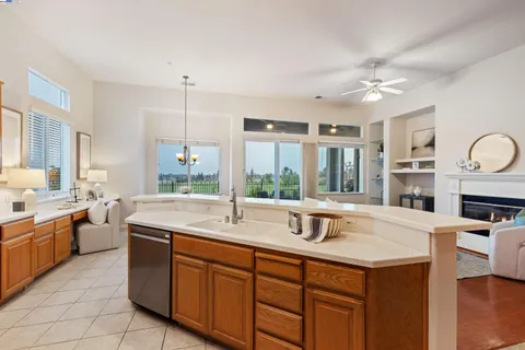 a kitchen with a sink a stove cabinets and wooden floor