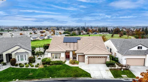 a view of a house with a big yard and large trees
