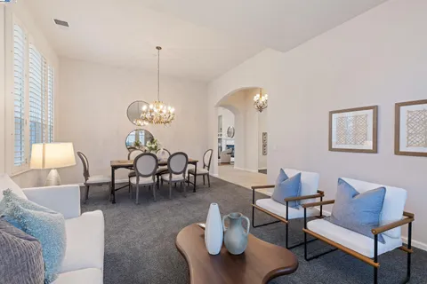a dining room with furniture a chandelier and wooden floor