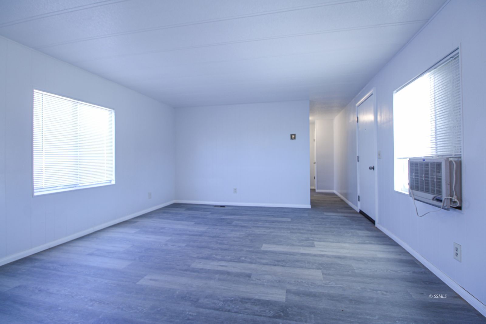 1441 West Iowa Avenue Ridgecrest, CA 93555 - Photo 6 of 27 a view of an empty room with a window and wooden floor