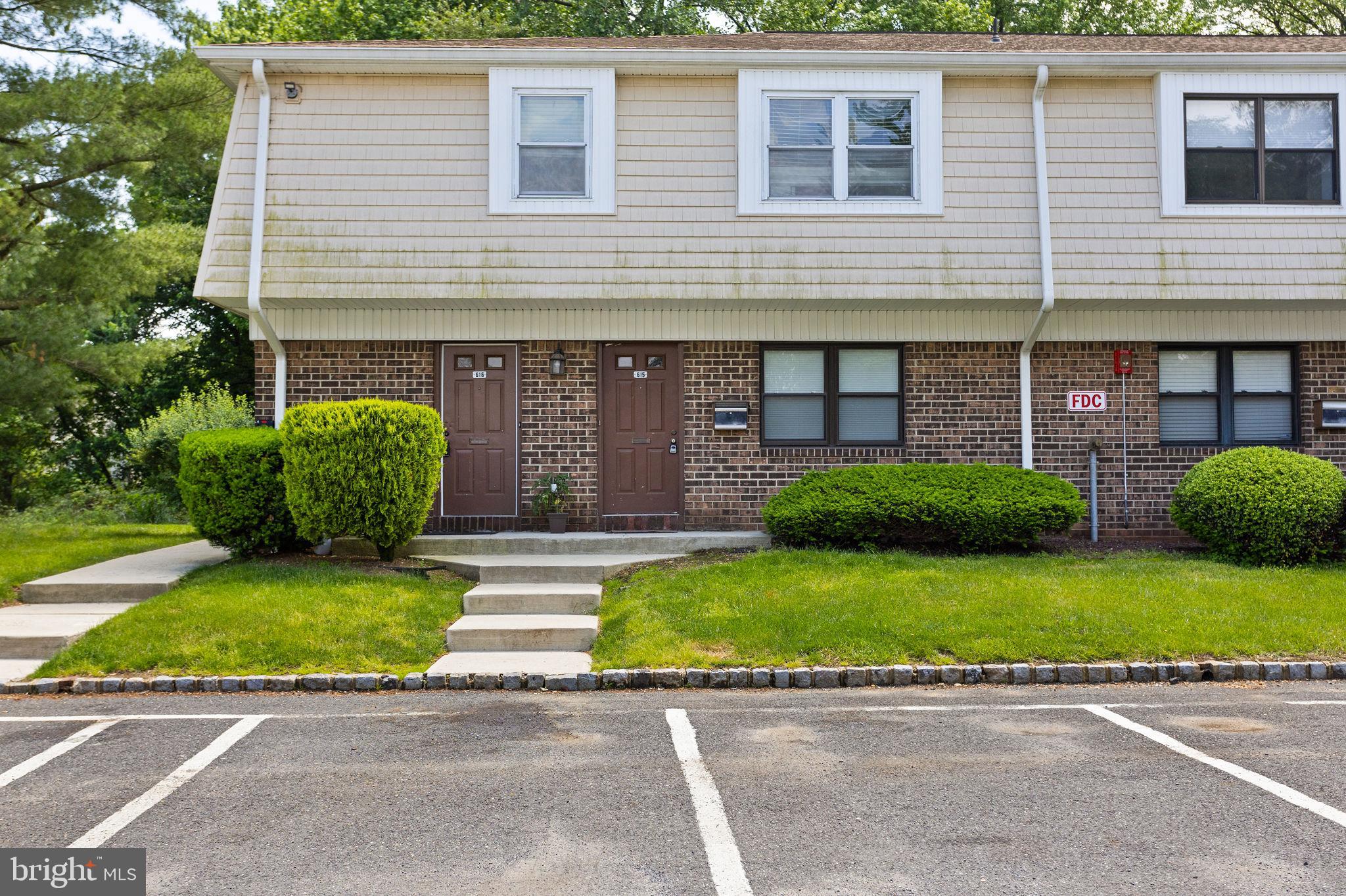 a front view of a house with a garden and plants