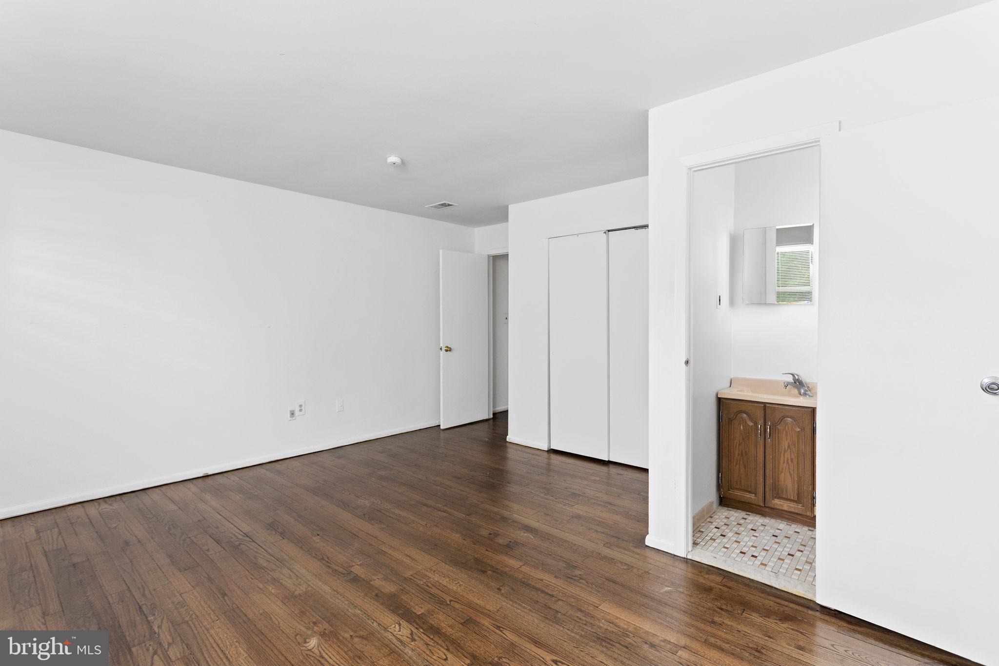 615 Silver Court Hamilton, NJ 08690 - Photo 14 of 22 an empty room with wooden floor and mirror
