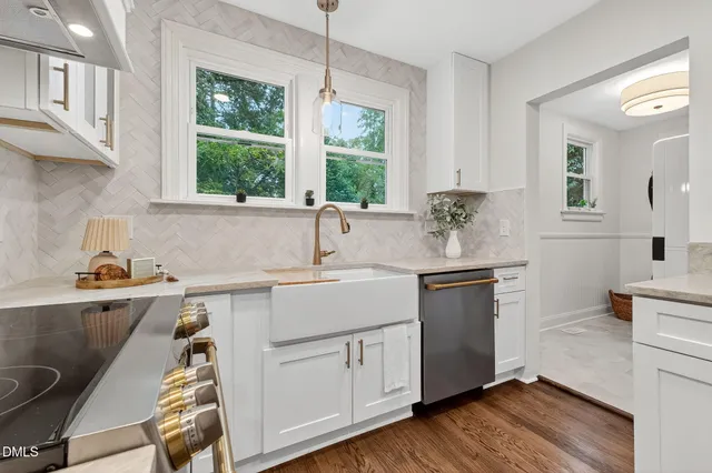a kitchen with a sink cabinets appliances and a window