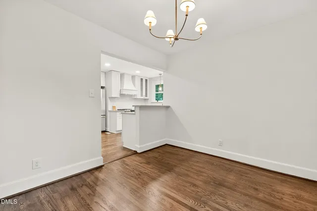 an empty room with wooden floor and ceiling fan