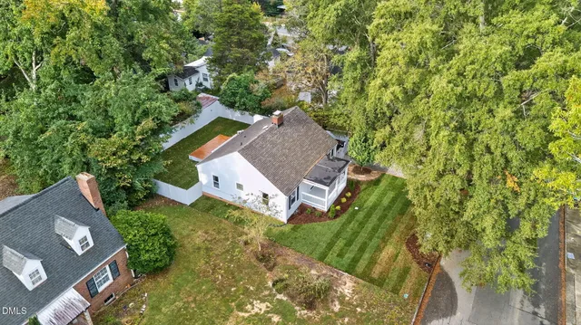 an aerial view of residential house with outdoor space and trees all around