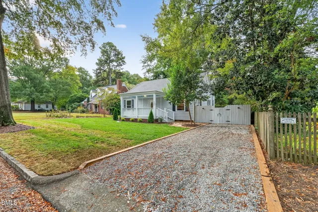 a view of a house with backyard and trees