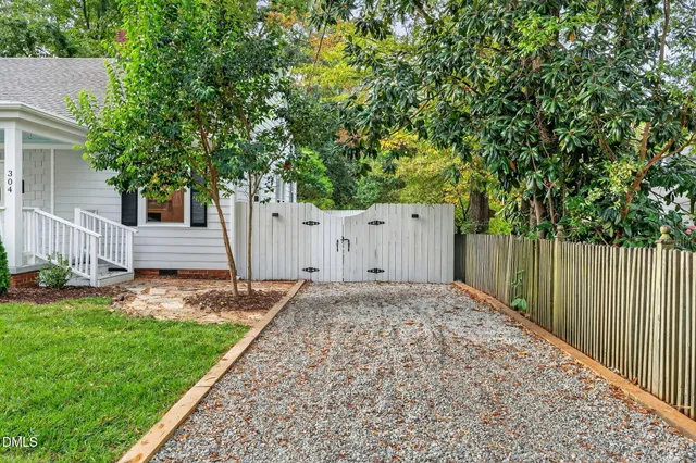 a view of a backyard with a large tree and wooden fence