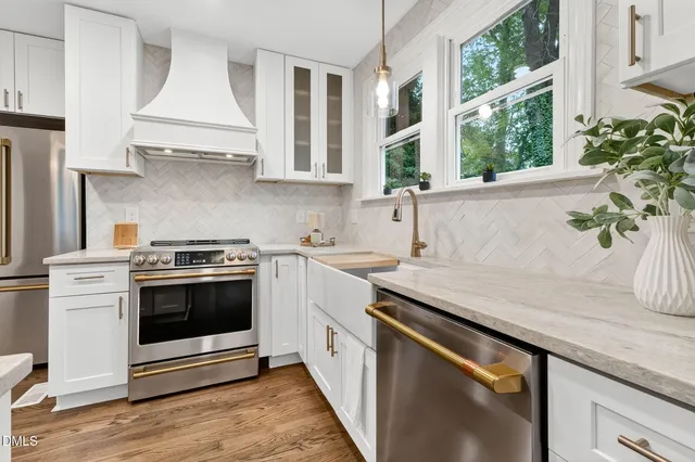 a kitchen with stainless steel appliances white cabinets and a window
