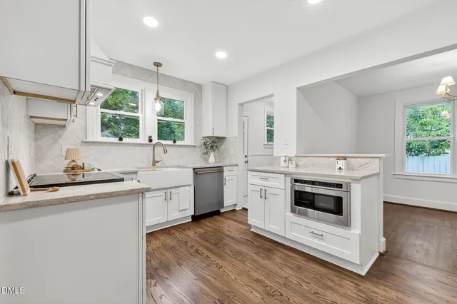a kitchen with a stove a sink and a window