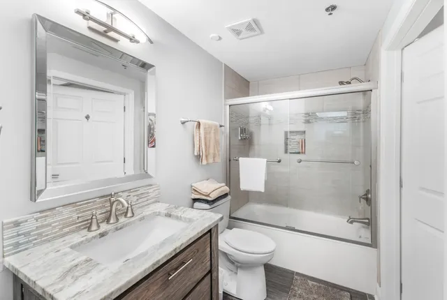 a bathroom with a sink toilet a mirror and shower