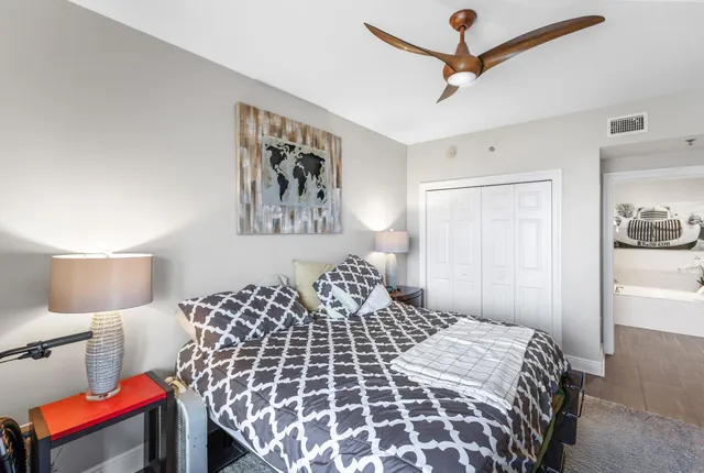 a bedroom with a large bed and a lamp on a dresser