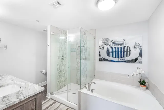 a bathroom with a granite countertop tub sink and mirror