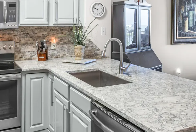 a kitchen with granite countertop a sink and a stove