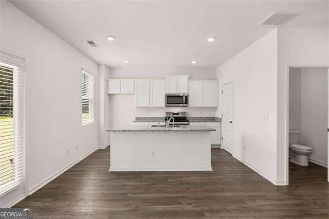 a view of kitchen with wooden floor and electronic appliances