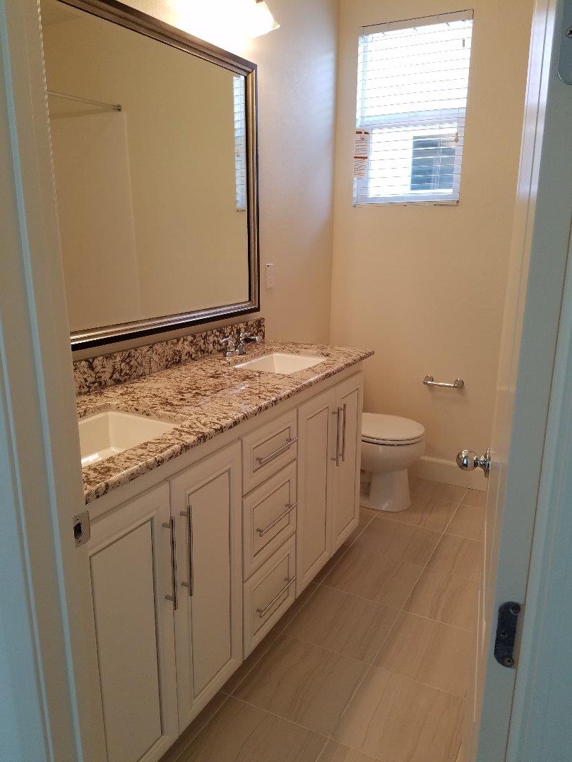Caspian Way Gilroy, CA 95020 - Photo 12 of 13 a bathroom with a granite countertop sink toilet and mirror