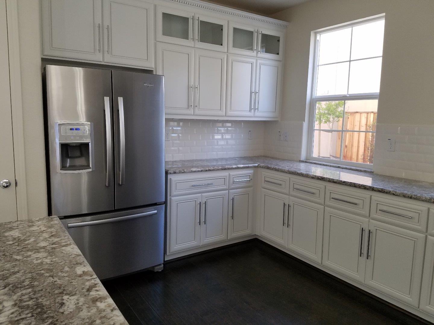 Caspian Way Gilroy, CA 95020 - Photo 4 of 13 a kitchen with white cabinets and refrigerator
