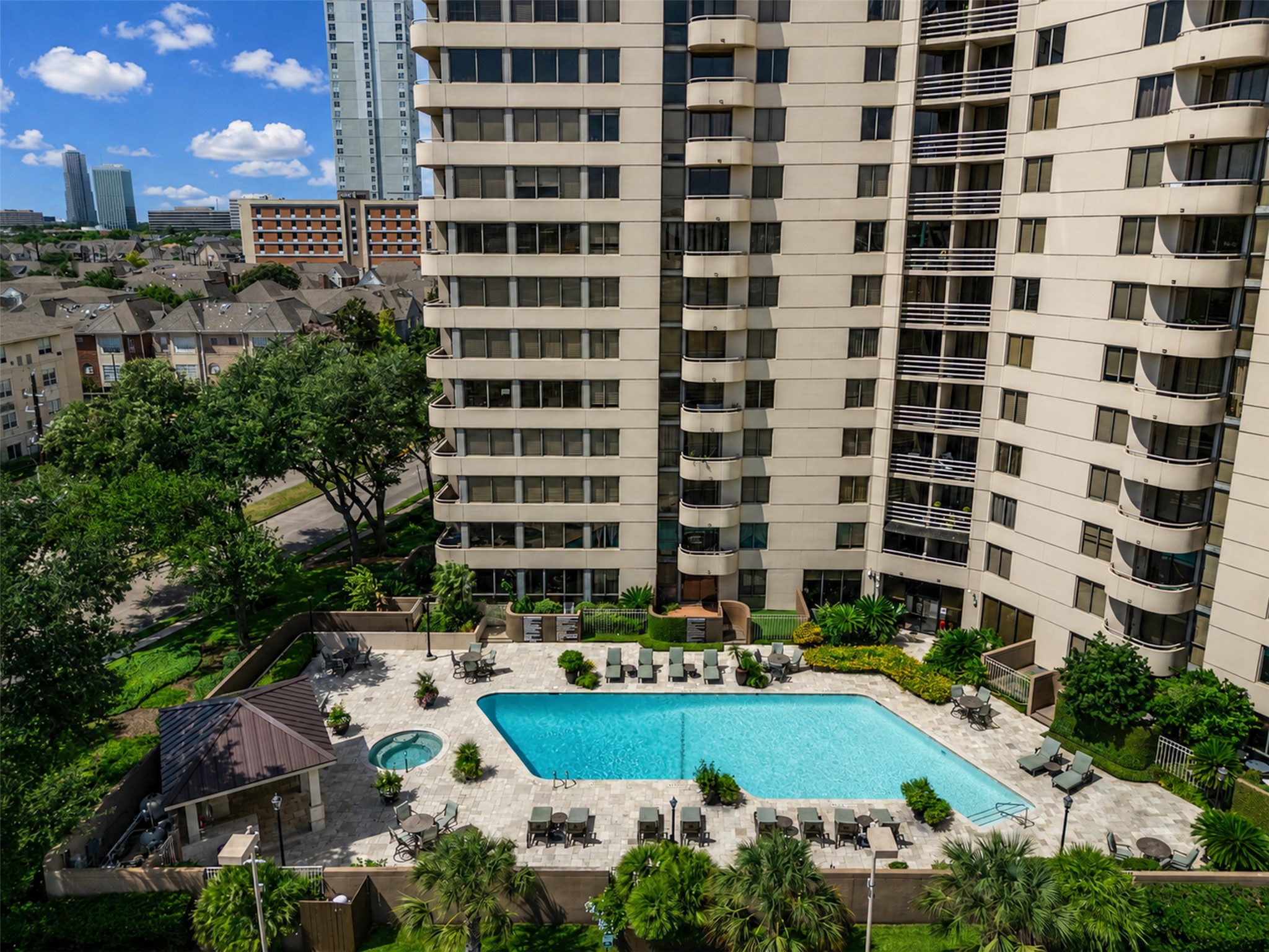 3525 Sage Road, Unit 1210 Houston, TX 77056 - Photo 15 of 20 Enjoy luxury living with this high-rise featuring a stunning pool and lush greenery, perfect for relaxation and entertainment.