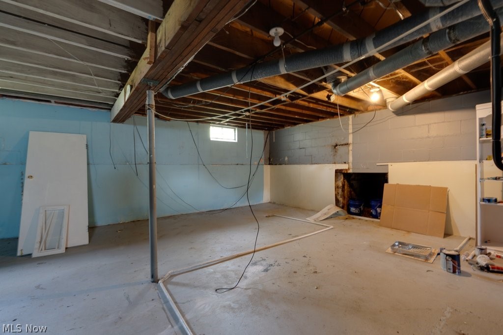 3569 Elm Road Stow, OH 44224 - Photo 15 of 17 Unfinished basement space featuring exposed wood joists, concrete flooring, painted cinder block walls, and a small window