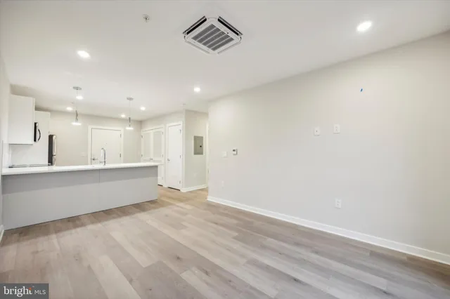 a view of kitchen with wooden floor and electronic appliances