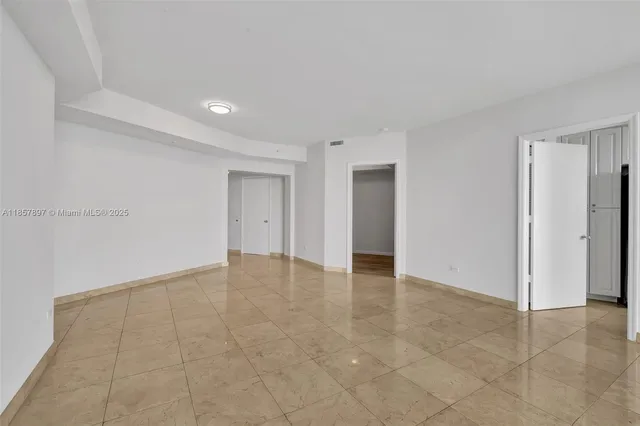 a view of an empty room with closet and a window