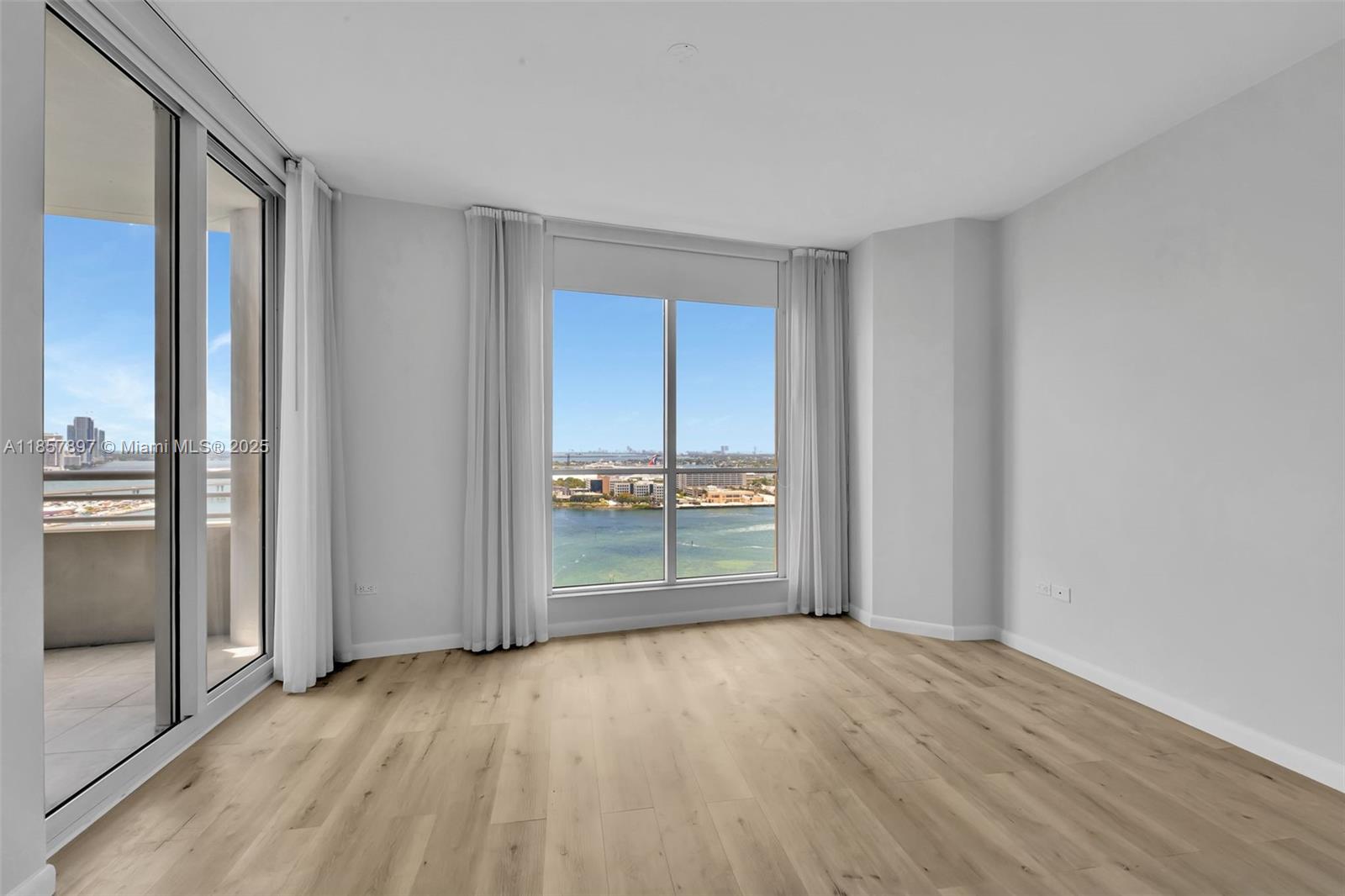 848 Brickell Key Drive, Unit 2602 Miami, FL 33131 - Photo 18 of 40 an empty room with wooden floor and door