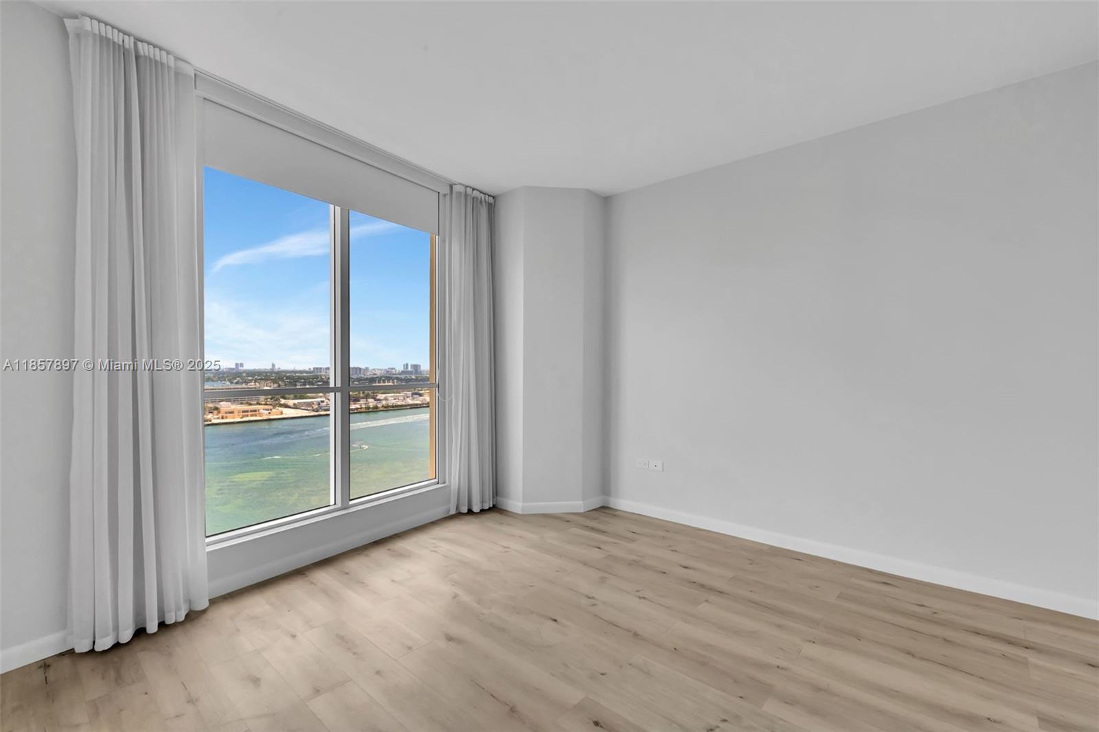 848 Brickell Key Drive, Unit 2602 Miami, FL 33131 - Photo 20 of 40 a view of an empty room with wooden floor and a window