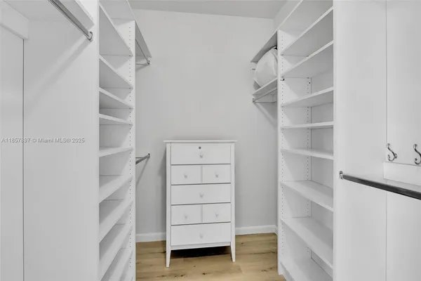 a view of walk in closet with empty racks