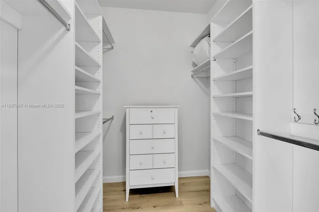 a view of walk in closet with empty racks