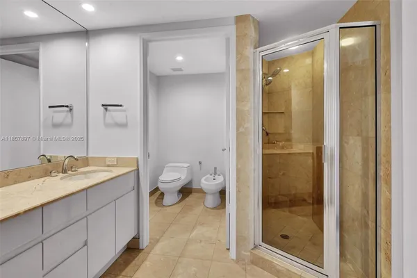 a spacious bathroom with a granite countertop sink toilet and shower