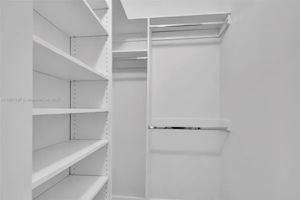 a view of walk in closet with empty racks