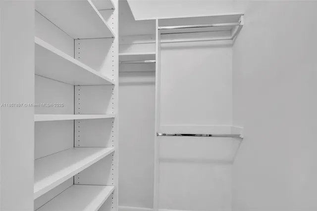a view of walk in closet with empty racks