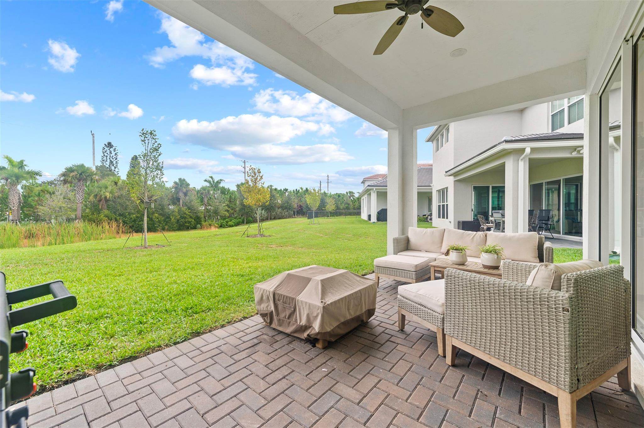 121 Southeast Rocky Terrace Stuart, FL 34997 - Photo 37 of 45 a view of a patio with couches chairs and a big yard