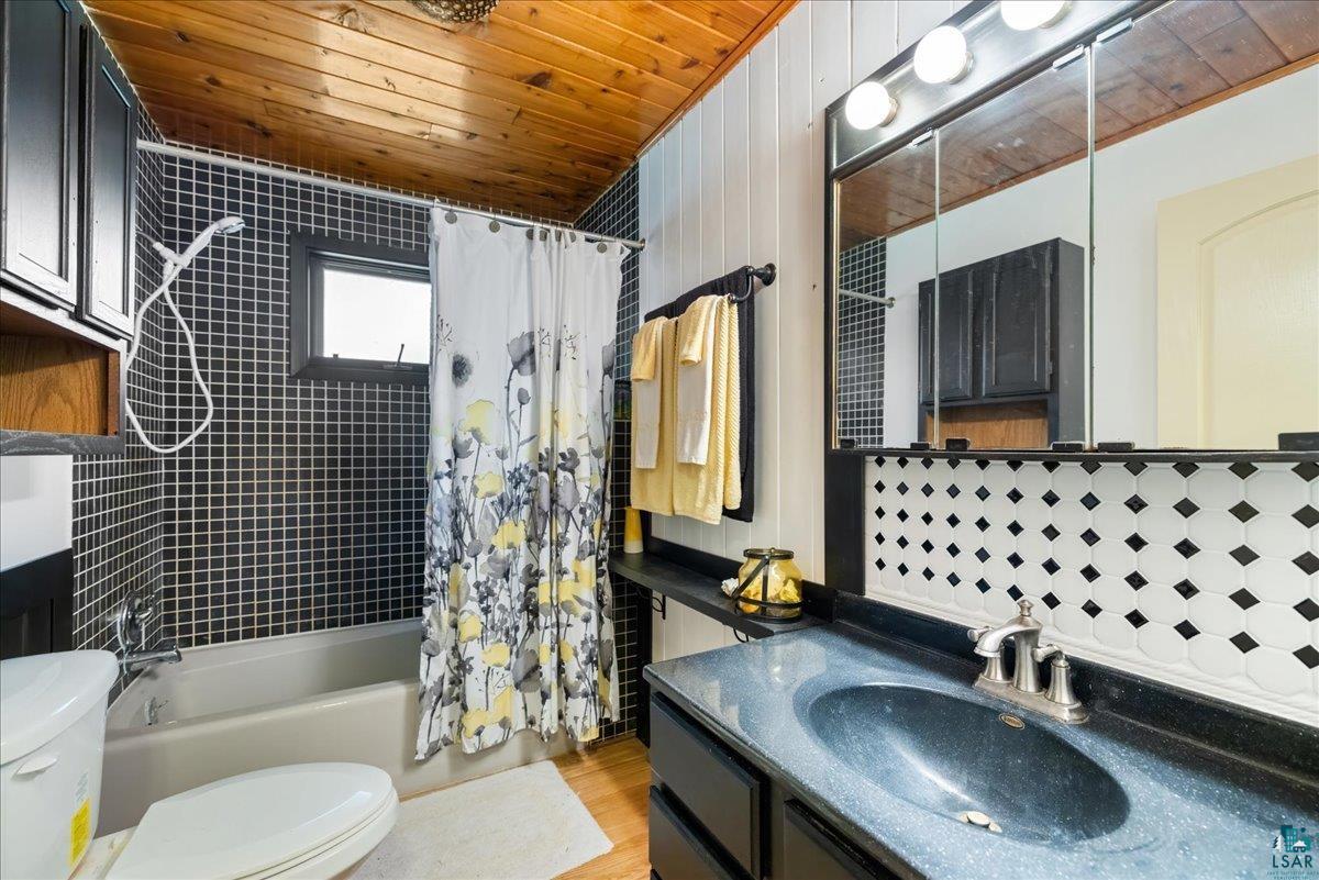 1804 North Bay Road Ely, MN 55731 - Photo 19 of 37 Full bathroom with shower / bath combo with shower curtain, toilet, vanity, wooden ceiling, and hardwood / wood-style flooring