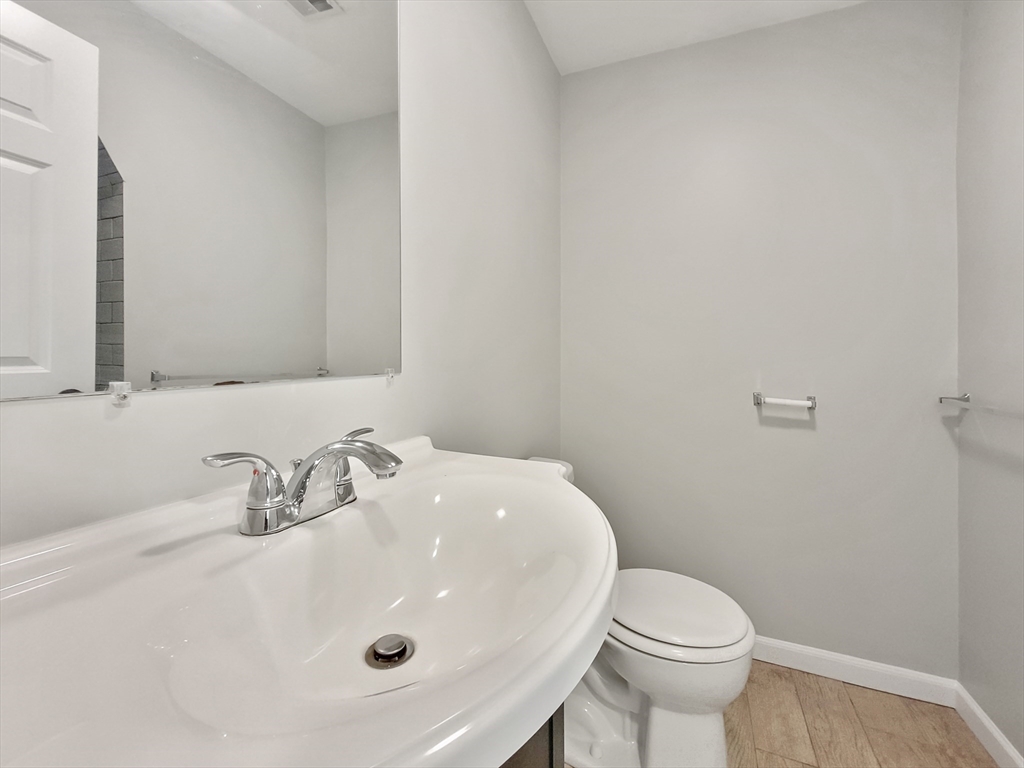 26 Arcadia Street, Unit 2L Boston, MA 02122 - Photo 7 of 9 a bathroom with a sink a toilet and mirror