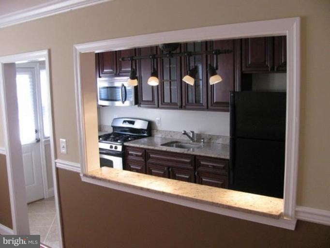 1629 Northgate Road Baltimore, MD 21218 - Photo 3 of 29 a kitchen with granite countertop a refrigerator and a stove top oven