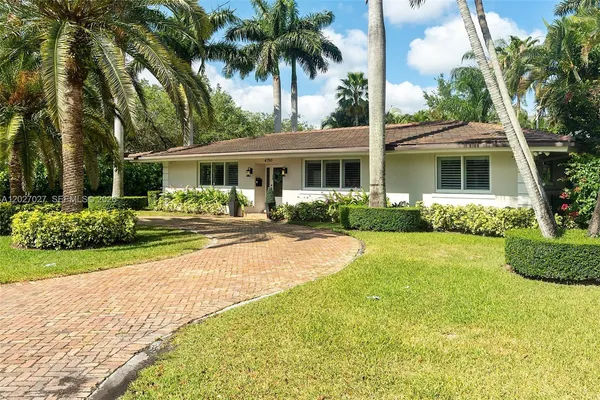 a front view of a house with yard and green space