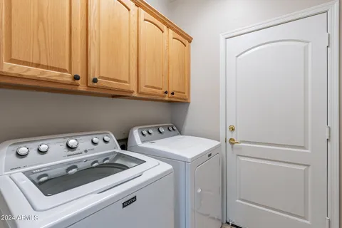 a view of washer and dryer with bathroom in the background