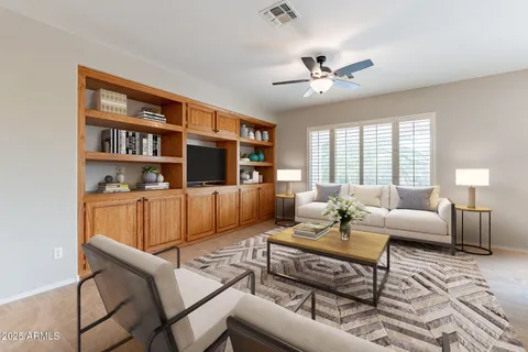 a living room with furniture ceiling fan and a window
