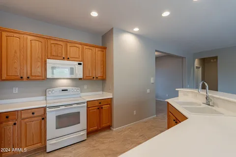 a kitchen with stainless steel appliances granite countertop a sink and cabinets with wooden floor