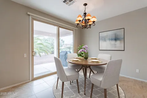 a view of a dining room with furniture a chandelier and wooden floor