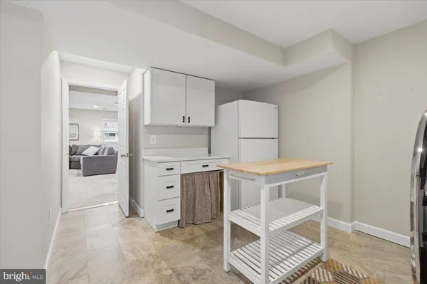 a kitchen with white cabinets and white appliances