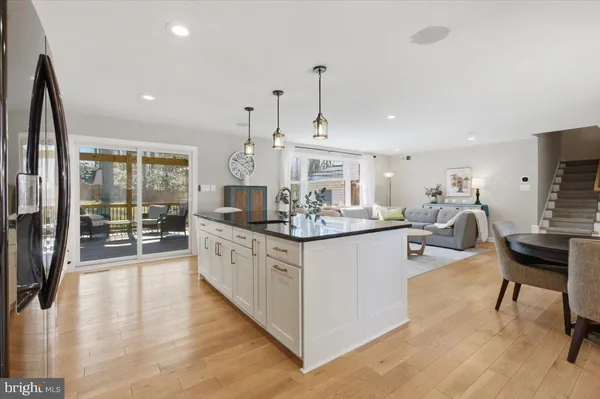a large kitchen with kitchen island a large counter top space a sink stainless steel appliances and cabinets