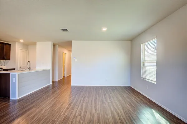 a view of a kitchen with a fridge and wooden floor