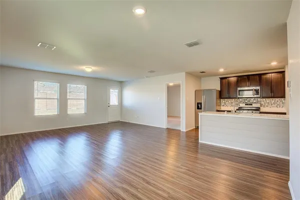 a view of kitchen with wooden floor and electronic appliances