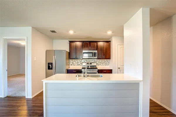 a view of kitchen with refrigerator stove and microwave