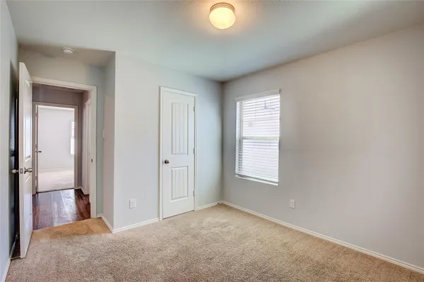 an empty room with windows and closet