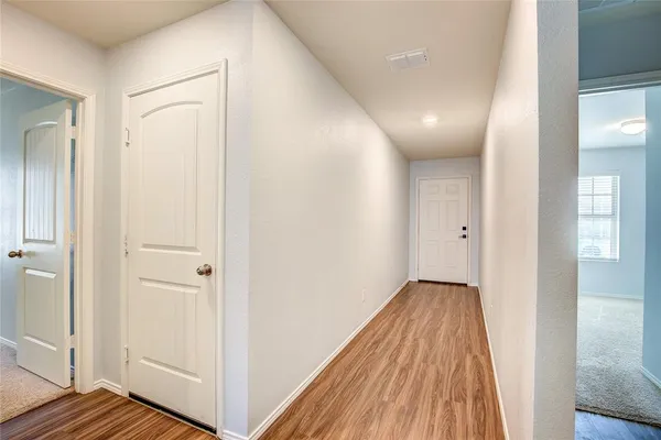 a view of a hallway with wooden floor