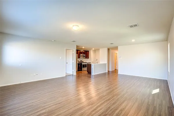 a view of a kitchen with wooden floor and a refrigerator