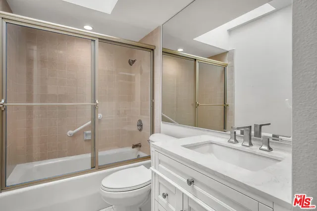 a bathroom with a granite countertop sink toilet and shower