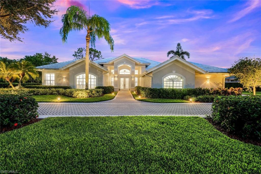 a front view of a house with a garden and yard